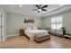 Relaxing bedroom featuring a tray ceiling, ceiling fan, light green walls, and bright light at 3712 76Th E St, Palmetto, FL 34221