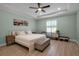 Bright bedroom features a ceiling fan, light-toned walls, wood floors, and windows with white shutters at 3712 76Th E St, Palmetto, FL 34221