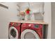 Modern laundry room featuring red washer and dryer set with countertop and wire shelving at 3712 76Th E St, Palmetto, FL 34221