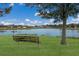 A serene pond view features a weathered bench beneath a shady tree, inviting residents to pause and enjoy the peaceful scenery at 3712 76Th E St, Palmetto, FL 34221