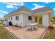 Backyard patio with white outdoor dining set and view of bright yellow exterior door at 386 Club Manor Dr, Sun City Center, FL 33573