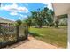 Charming backyard with brick-paved patio, metal garden gate, bird bath, and mature trees at 386 Club Manor Dr, Sun City Center, FL 33573