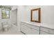 Bathroom with white cabinets, decorative mirror, white countertops, and white-tiled floor and shower/tub at 386 Club Manor Dr, Sun City Center, FL 33573