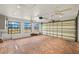 Spacious garage with brick floor, windows for natural light, and two ceiling fans at 386 Club Manor Dr, Sun City Center, FL 33573