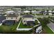 Aerial view of homes with green lawns, and screened-in pools near a tranquil pond at 4005 Willow Branch Pl, Palmetto, FL 34221