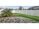 Green backyard features a paved patio, grass, palm trees, and a white vinyl fence at 4005 Willow Branch Pl, Palmetto, FL 34221