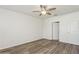 Clean and bright bedroom showcasing wood-look floors, a ceiling fan, and a door leading to the hallway at 4005 Willow Branch Pl, Palmetto, FL 34221