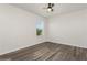 Clean bedroom with wood-look flooring, ceiling fan, a window and neutral paint offers a cozy space at 4005 Willow Branch Pl, Palmetto, FL 34221