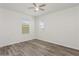 Bright bedroom with wood-look flooring, a ceiling fan and large windows offers a serene retreat at 4005 Willow Branch Pl, Palmetto, FL 34221