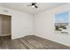 Bedroom with wood-look flooring, ceiling fan and window offers an inviting, functional living space at 4005 Willow Branch Pl, Palmetto, FL 34221