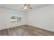 Cozy bedroom featuring modern ceiling fan, wood-look flooring, and a sunny window with privacy blinds at 4005 Willow Branch Pl, Palmetto, FL 34221