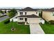 Two-story home with a two-car garage, surrounded by lush greenery and a white picket fence at 4005 Willow Branch Pl, Palmetto, FL 34221