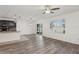 Open-concept living room with wood-look flooring, a ceiling fan, and sliding glass doors to the backyard at 4005 Willow Branch Pl, Palmetto, FL 34221