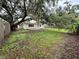 Expansive backyard featuring lush green grass and mature shade trees, creating a serene outdoor space at 4110 Longhorn Dr, Sarasota, FL 34233