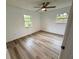 Bright bedroom features wood-look floors, ceiling fan, and natural light from two windows at 4110 Longhorn Dr, Sarasota, FL 34233