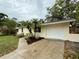 Inviting single-story home with a white garage door, a well-maintained yard, and lush palm trees at 4110 Longhorn Dr, Sarasota, FL 34233