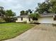 Charming home exterior featuring a well-maintained lawn, landscaping, and paved driveway at 4110 Longhorn Dr, Sarasota, FL 34233