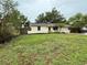 Charming one-story home with a spacious front yard, complemented by mature trees, bushes, and green grass at 4110 Longhorn Dr, Sarasota, FL 34233