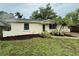 Charming home boasts lush landscaping, a vibrant green lawn, and a meticulously mulched garden at 4110 Longhorn Dr, Sarasota, FL 34233