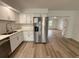 Open kitchen area with stainless steel refrigerator and white cabinets looking into the living room at 4110 Longhorn Dr, Sarasota, FL 34233