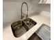 Close-up of a stainless steel, undermount kitchen sink with white countertops and a pull-down faucet at 4110 Longhorn Dr, Sarasota, FL 34233