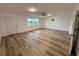 Bright living room with wood-look floors, a ceiling fan, and a large window offering natural light at 4110 Longhorn Dr, Sarasota, FL 34233