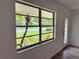 Bright living room window view of lush greenery and front yard landscaping, letting in natural light at 4110 Longhorn Dr, Sarasota, FL 34233