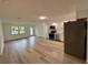 Open living area with new wood-look flooring, connecting to the kitchen and dining space at 4110 Longhorn Dr, Sarasota, FL 34233