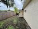 Narrow side yard with limited grass and a view of a wooden fence separating the property at 4110 Longhorn Dr, Sarasota, FL 34233