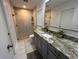 Updated bathroom featuring a tiled shower, granite vanity, and modern fixtures at 4441 Groveland Ave, Sarasota, FL 34231
