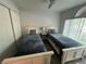 Bright bedroom featuring two beds, a ceiling fan, large window and closet at 4441 Groveland Ave, Sarasota, FL 34231