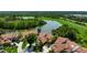 Beautiful home with a red tile roof situated on a lush, green golf course with a scenic lake at 4472 Calle Serena, Sarasota, FL 34238
