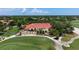 Elegant clubhouse with a red tile roof and outdoor patio overlooking the lush golf course at 4472 Calle Serena, Sarasota, FL 34238