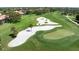 Sand trap on a meticulously maintained golf course, framed by green fairways and palm trees at 4472 Calle Serena, Sarasota, FL 34238