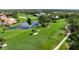 Scenic view of the lush green golf course with a tranquil pond and mature trees at 4472 Calle Serena, Sarasota, FL 34238
