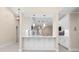 Pass through kitchen with white cabinets, pendant lights, and breakfast bar area at 4472 Calle Serena, Sarasota, FL 34238