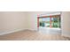 Bright living room features wood floors and sliding glass doors to a screened patio at 4472 Calle Serena, Sarasota, FL 34238