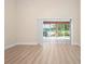 Spacious living room features wood floors and sliding glass doors to a screened patio at 4472 Calle Serena, Sarasota, FL 34238