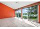 Enclosed patio features serene lake views, tile flooring, and an orange accent wall at 4472 Calle Serena, Sarasota, FL 34238