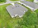 An aerial view of a single-story home with a gray roof, green lawn, and mature trees at 4610 Clarke St, North Port, FL 34286