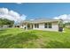Spacious backyard with a covered patio and lush green lawn, perfect for outdoor living at 4610 Clarke St, North Port, FL 34286