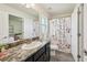 Full bathroom with a floral shower curtain, dark cabinets, and a large mirror at 4610 Clarke St, North Port, FL 34286