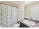 Bathroom with stylish gray and blue shower curtain and granite-look countertop vanity at 4610 Clarke St, North Port, FL 34286