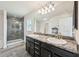 Modern bathroom featuring a double vanity, elegant mirror, and tiled walk-in shower at 4610 Clarke St, North Port, FL 34286