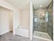Modern bathroom featuring a soaking tub and glass-enclosed shower with decorative tile at 4610 Clarke St, North Port, FL 34286