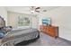 Cozy bedroom with carpet flooring, wood dresser, and a window view at 4610 Clarke St, North Port, FL 34286