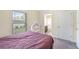 Well-lit bedroom features a large window, gray carpet, and a cozy purple bed at 4610 Clarke St, North Port, FL 34286