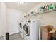 Functional laundry room with modern washer and dryer, and shelving for storage at 4610 Clarke St, North Port, FL 34286