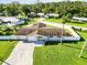 Aerial view of the house with lush lawn, fenced backyard, and a long driveway at 5200 Malaga Ave, Sarasota, FL 34235