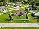This aerial shot displays the home nestled in a well-maintained neighborhood featuring a full fence and lush green lawn at 5200 Malaga Ave, Sarasota, FL 34235